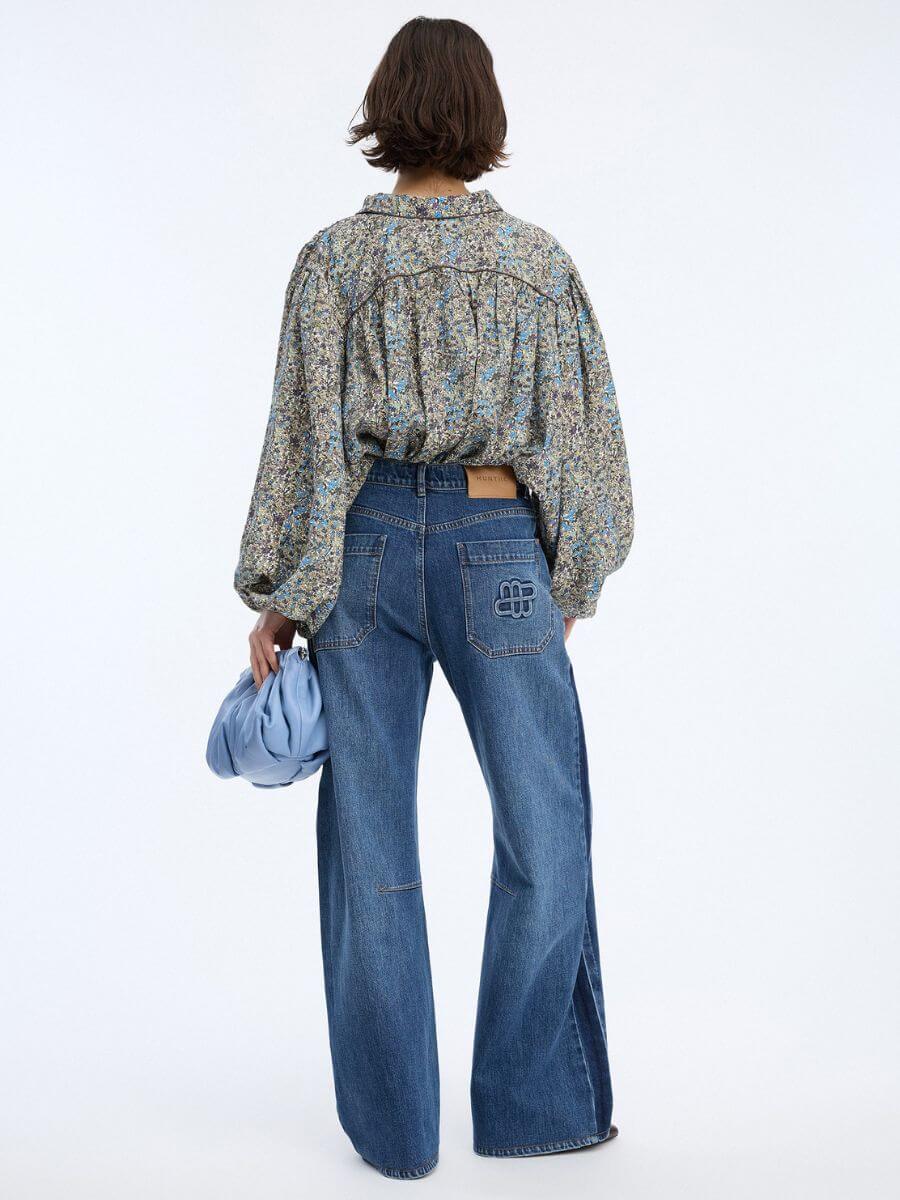 Munthe - Bohdi Jeans - Indigo - back view - styled with floral shirt, baby blue leather clutch bag and high heels - showing jean length just off the floor