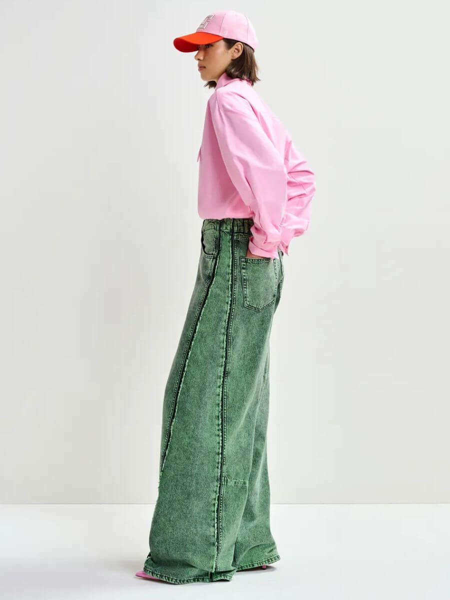 Essentiel Antwerp Jomato Shirt in Cotton Candy pink styled with pink/orange cap and grey wide leg jeans, side view
