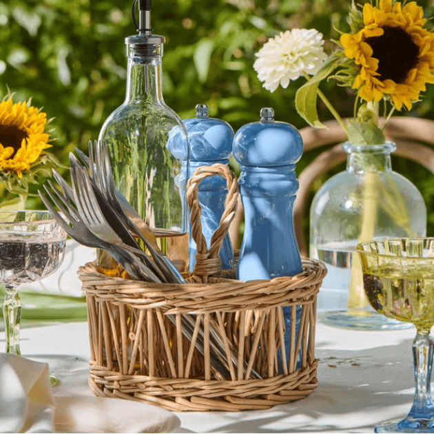 IB LAURSEN SALT AND PEPPER MILLS in light blue in basket on set table outside with sunflowers in vase behind