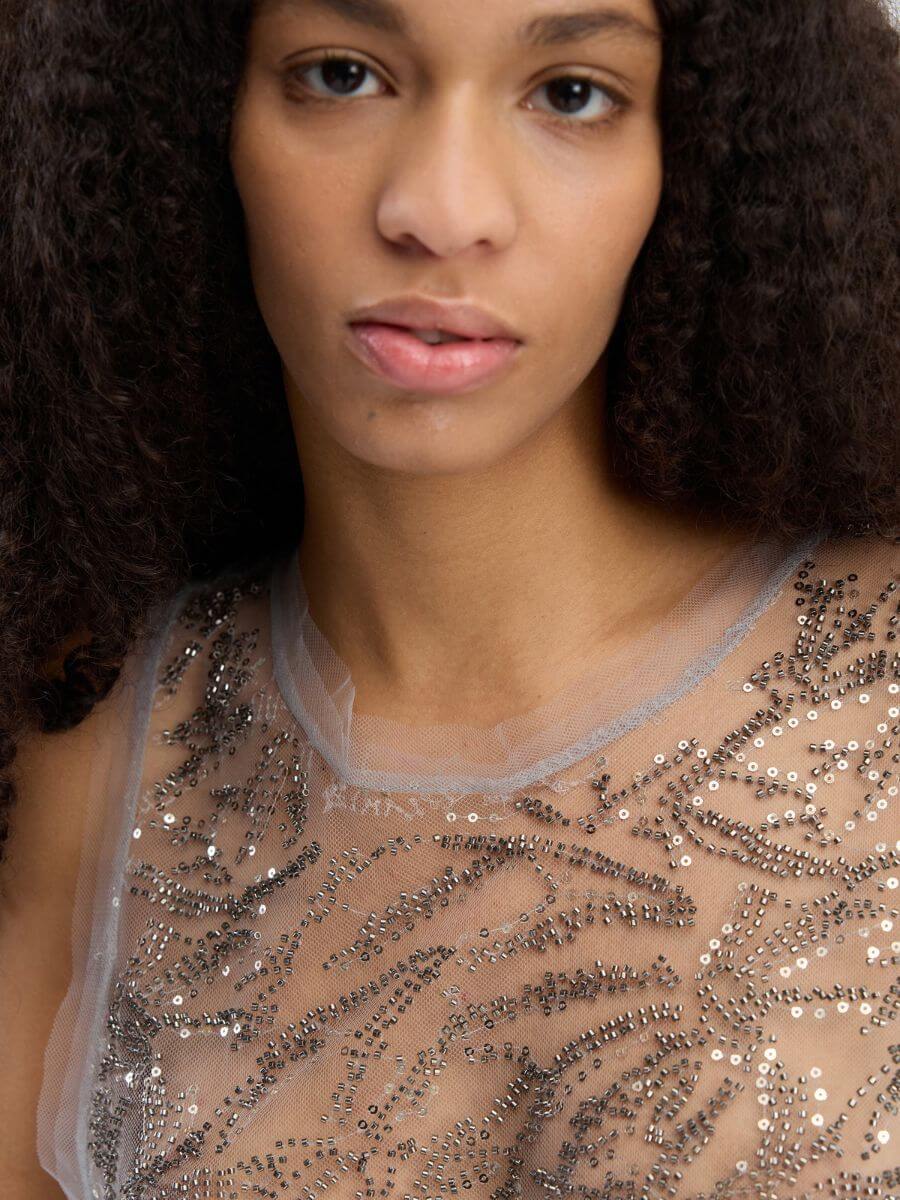 MUNTHE Varika Dress close up showing raw hems at neck and arm with 2 layers of the net fabric