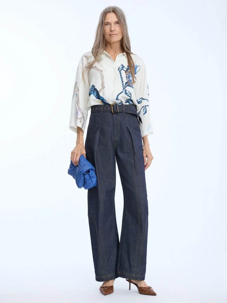 Munthe - Nanina Denim Pants styled with patterned loose fit shirt tucked in, blue leather slouchy clutch bag and brown pointed toe heels