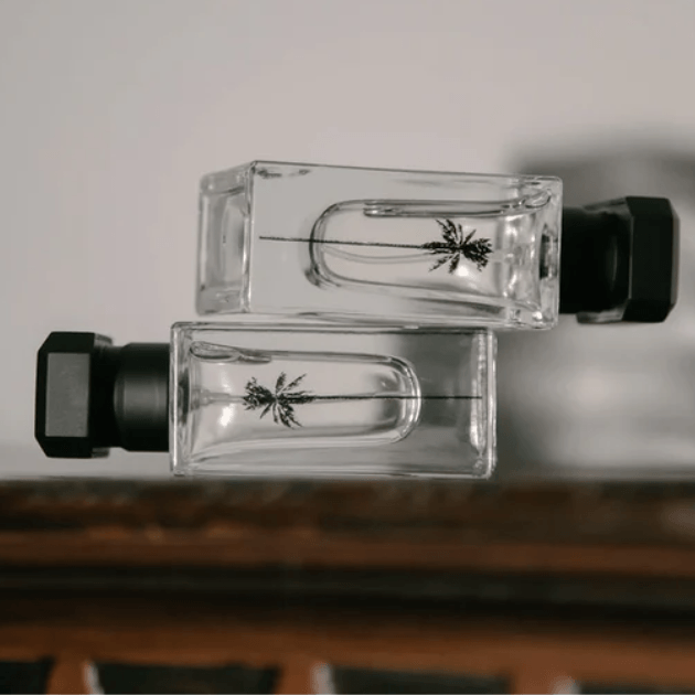 RAAW Perfume bottles stacked on their sides showing the side palm tree logo